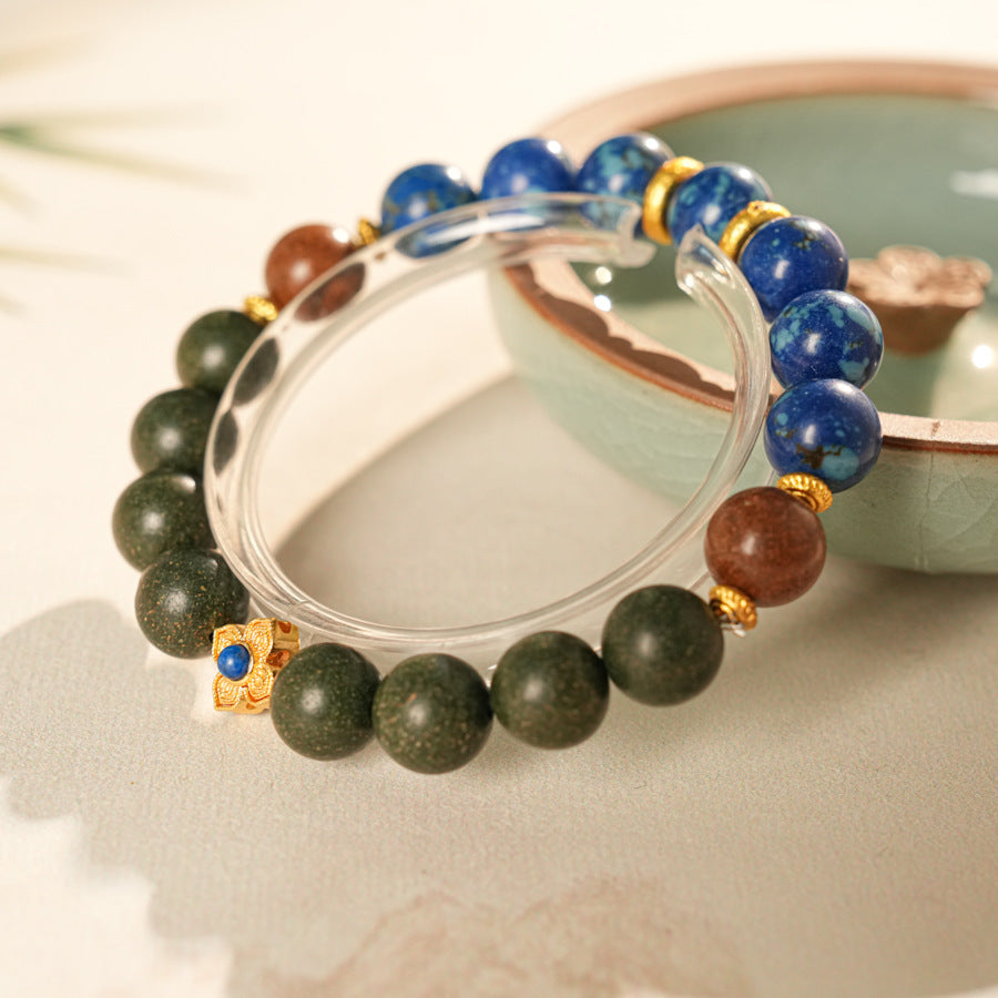 Wood-bead and lapis lazuli bracelet with a gold-tone floral charm set with a lapis cabochon — Woodland Lapis Charm Bracelet by Glazenya.