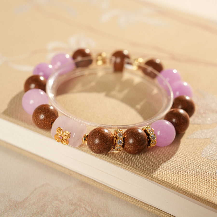 Handcrafted bracelet with pink and lavender crystals paired with sandalwood and gold floral accents — Lavender Serenity Bracelet by Glazenya.
