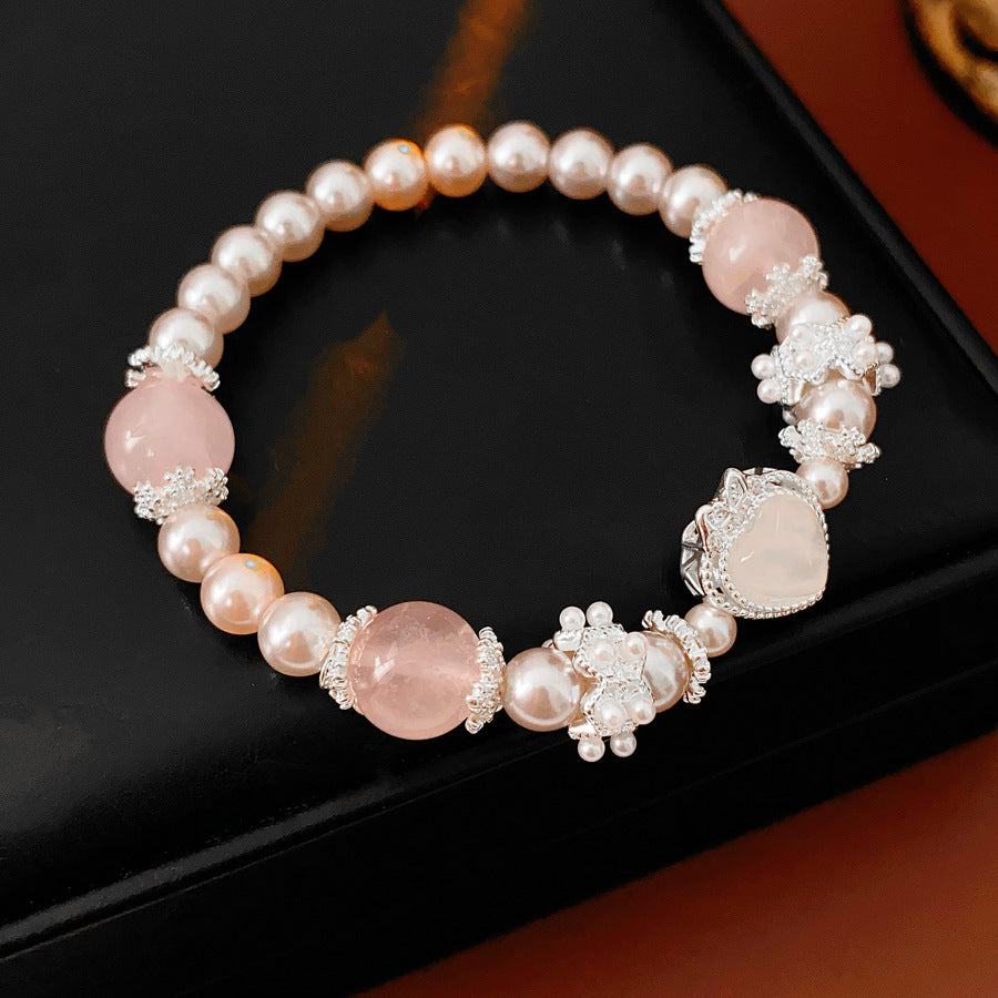 Rosy Heart Pearl Bracelet with pink crystal heart charm and luminous pearls on black background