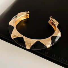 Gold-tone open cuff with triangular glossy enamel peaks; three variants (black, white, red) — Harlequin Enamel Cuff.