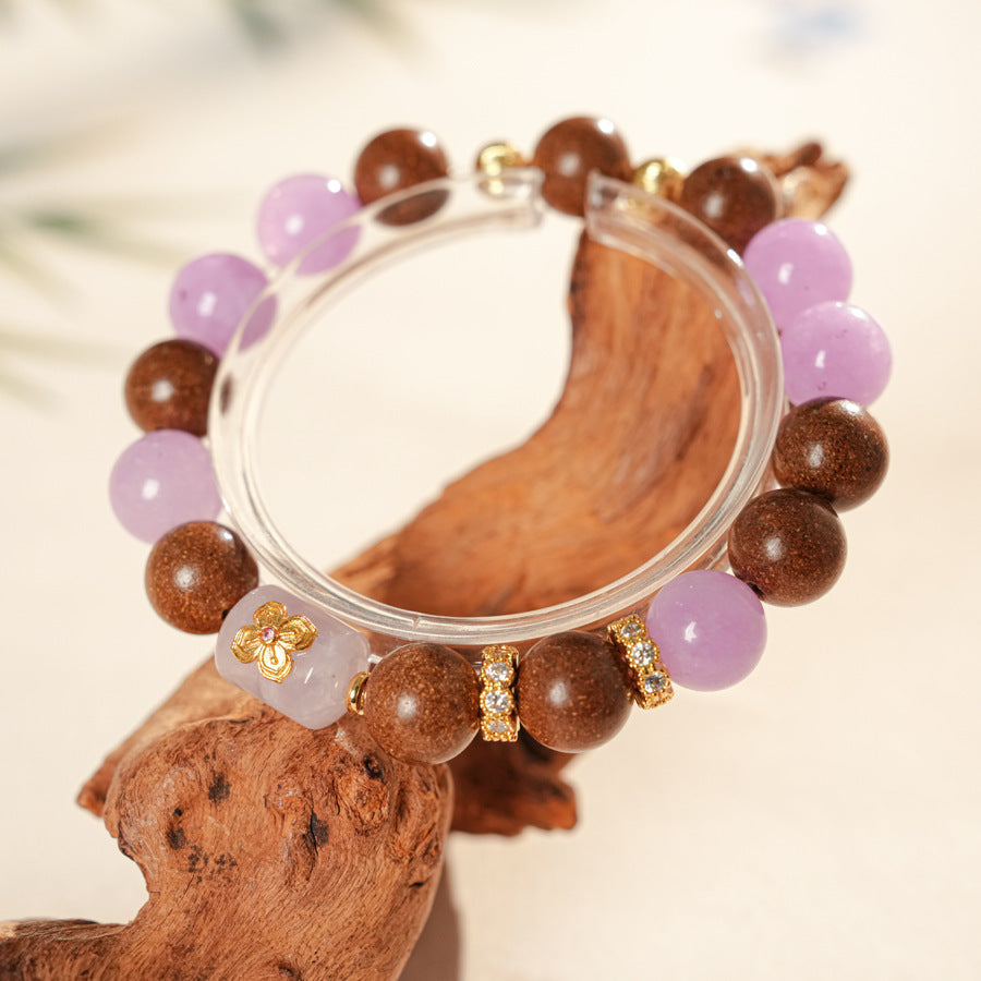 Handcrafted bracelet with pink and lavender crystals paired with sandalwood and gold floral accents — Lavender Serenity Bracelet by Glazenya.