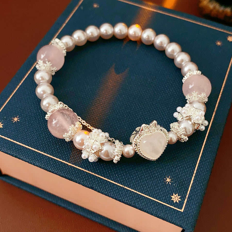 Rosy Heart Pearl Bracelet with pink crystal heart charm and luminous pearls on black background
