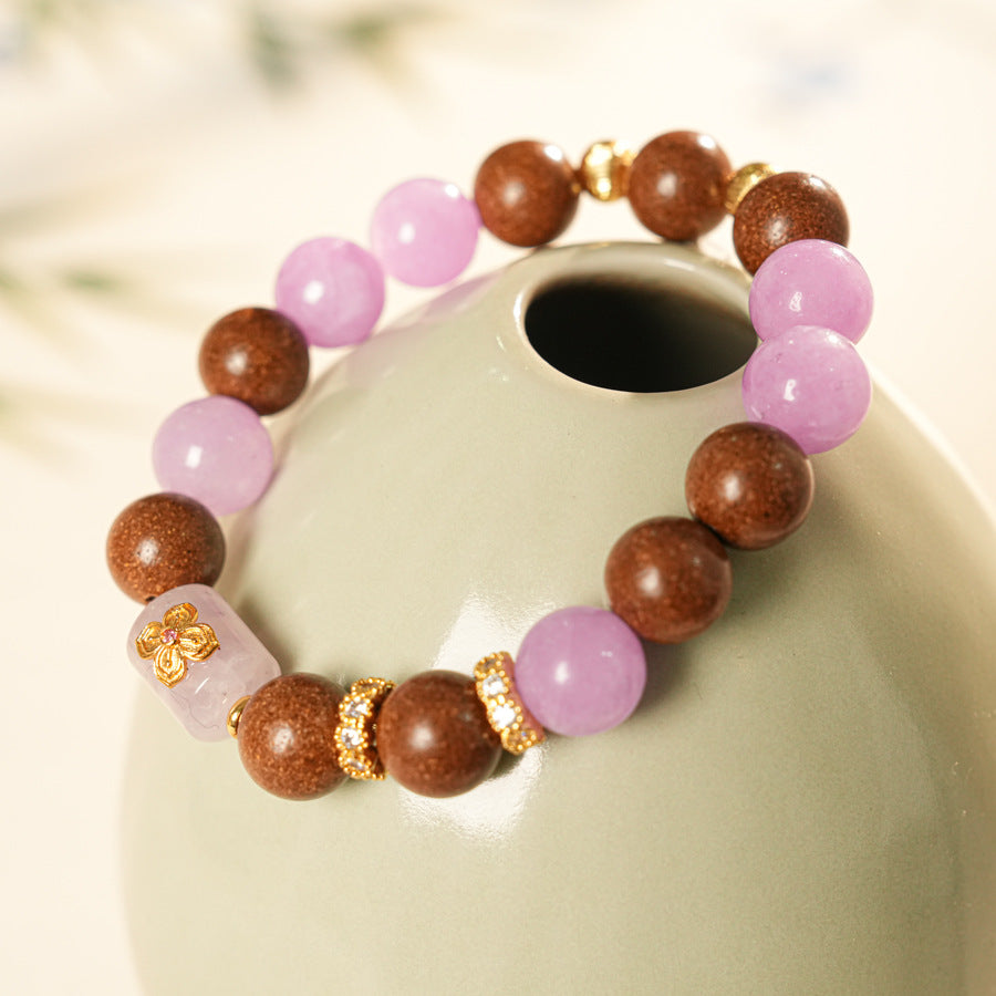 Handcrafted bracelet with pink and lavender crystals paired with sandalwood and gold floral accents — Lavender Serenity Bracelet by Glazenya.