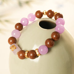 Handcrafted bracelet with pink and lavender crystals paired with sandalwood and gold floral accents — Lavender Serenity Bracelet by Glazenya.