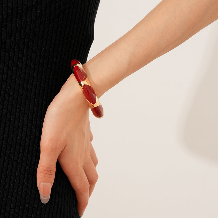 Gold-tone open cuff with triangular glossy enamel peaks; three variants (black, white, red) — Harlequin Enamel Cuff.