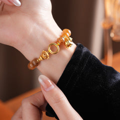 Gold-tone beaded bracelet with lotus charm and zircon accents — Golden Lotus Prosperity Bracelet by Glazenya.