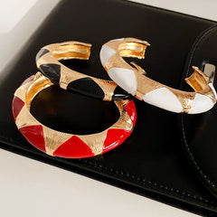Gold-tone open cuff with triangular glossy enamel peaks; three variants (black, white, red) — Harlequin Enamel Cuff.
