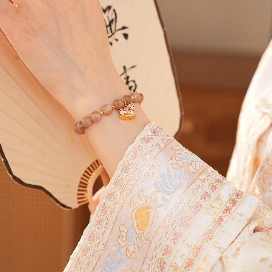 Peach sunstone beaded bracelet with a small gold-tone rocking horse charm — Sunstone Rocking Horse Bracelet by Glazenya.