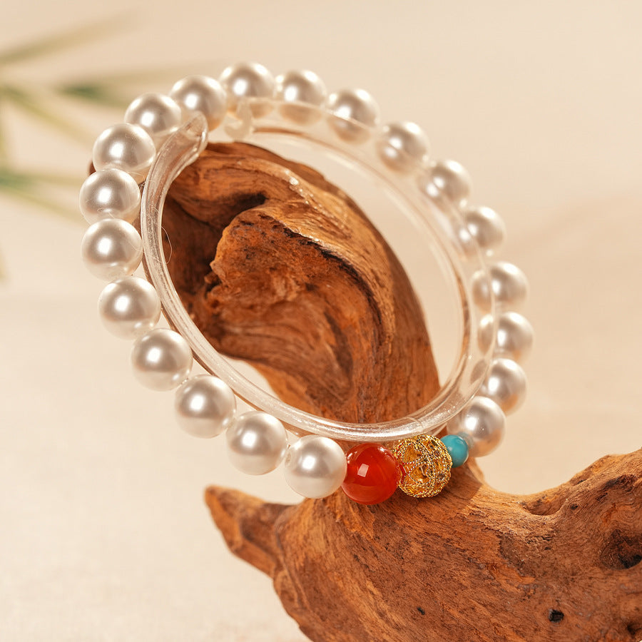 White/blush Shijia pearl bracelet featuring a red agate bead, gold zircon bead, and small blue accent — Trio Charm Pearl Bracelet by Glazenya.