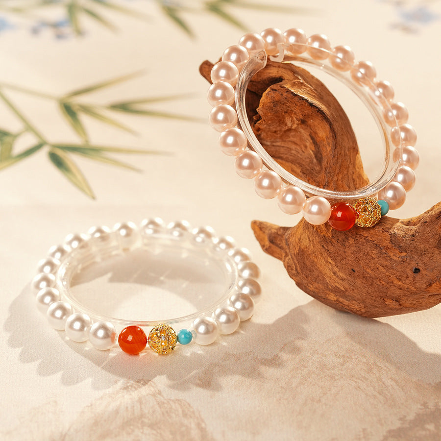 White/blush Shijia pearl bracelet featuring a red agate bead, gold zircon bead, and small blue accent — Trio Charm Pearl Bracelet by Glazenya.