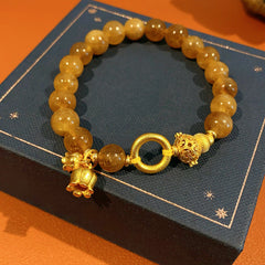 Gold-tone beaded bracelet with lotus charm and zircon accents — Golden Lotus Prosperity Bracelet by Glazenya.
