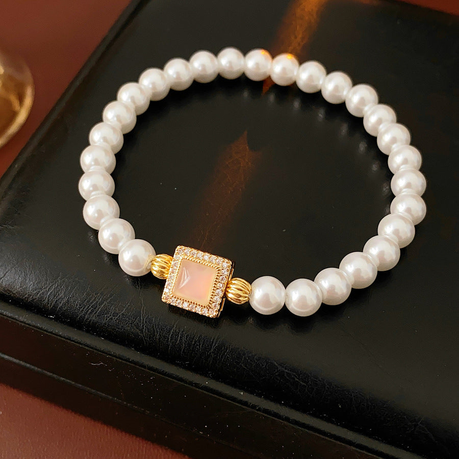 Blush Square Pearl Bracelet, a bracelet featuring lustrous pearls and a pale pink square zircon pendant.