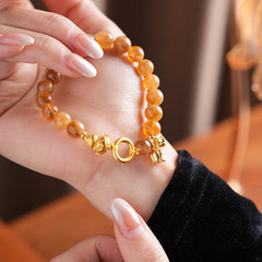 Gold-tone beaded bracelet with lotus charm and zircon accents — Golden Lotus Prosperity Bracelet by Glazenya.