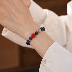 Lapis lazuli beaded bracelet with red accent bead and gold spacers — Midnight Sun Lapis Bracelet by Glazenya.