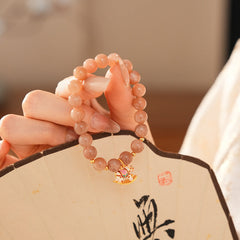 Peach sunstone beaded bracelet with a small gold-tone rocking horse charm — Sunstone Rocking Horse Bracelet by Glazenya.