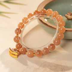 Peach sunstone beaded bracelet with a small gold-tone rocking horse charm — Sunstone Rocking Horse Bracelet by Glazenya.