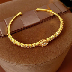 Elegant open bangle in gold with sparkling zircon stones and a marquise centerpiece, light-luxury adjustable bracelet.