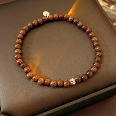 Wood-grain beaded bracelet with small gold-tone copper accent — Woodgrain Whisper Bracelet by Glazenya.