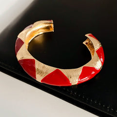 Gold-tone open cuff with triangular glossy enamel peaks; three variants (black, white, red) — Harlequin Enamel Cuff.