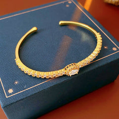 Elegant open bangle in gold with sparkling zircon stones and a marquise centerpiece, light-luxury adjustable bracelet.