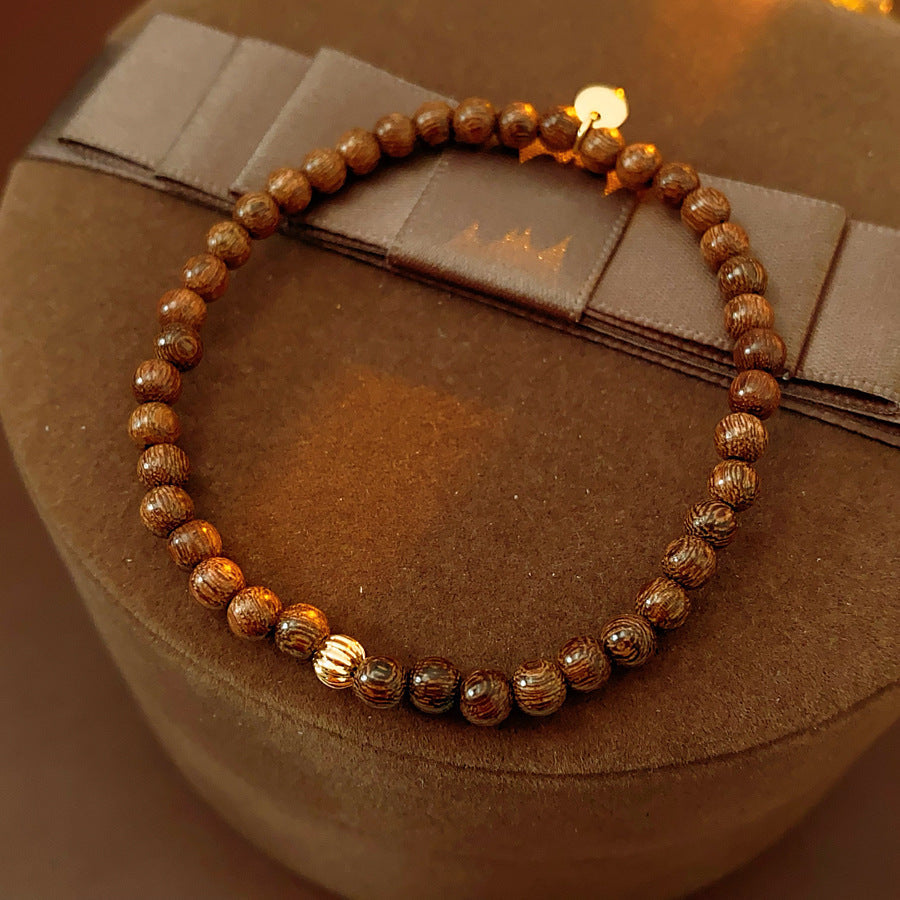 Wood-grain beaded bracelet with small gold-tone copper accent — Woodgrain Whisper Bracelet by Glazenya.