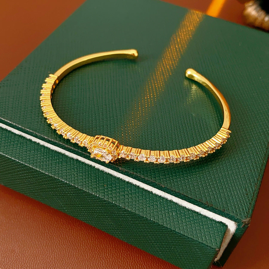 Elegant open bangle in gold with sparkling zircon stones and a marquise centerpiece, light-luxury adjustable bracelet