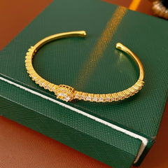 Elegant open bangle in gold with sparkling zircon stones and a marquise centerpiece, light-luxury adjustable bracelet