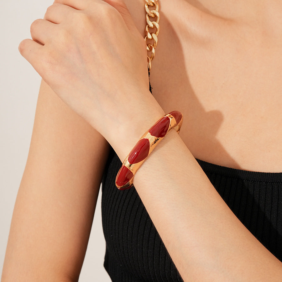 Gold-tone open cuff with triangular glossy enamel peaks; three variants (black, white, red) — Harlequin Enamel Cuff.