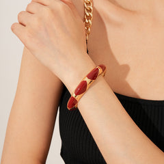 Gold-tone open cuff with triangular glossy enamel peaks; three variants (black, white, red) — Harlequin Enamel Cuff.
