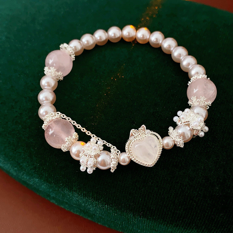 Rosy Heart Pearl Bracelet with pink crystal heart charm and luminous pearls on black background