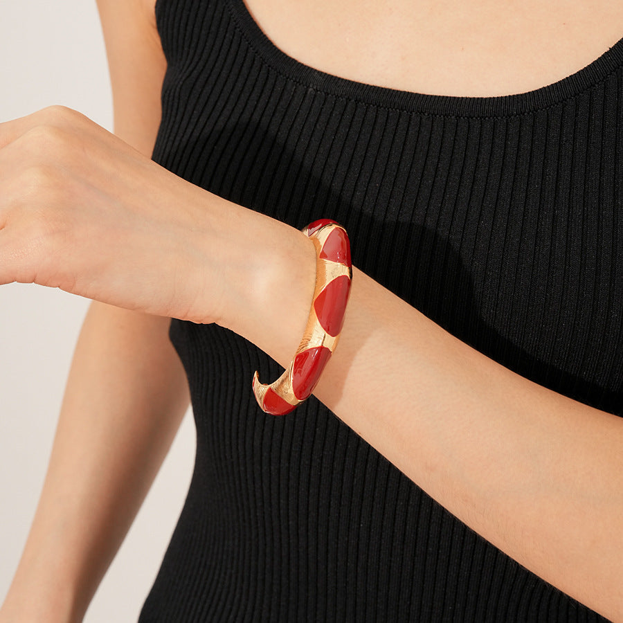 Gold-tone open cuff with triangular glossy enamel peaks; three variants (black, white, red) — Harlequin Enamel Cuff.