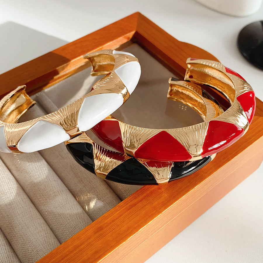 Gold-tone open cuff with triangular glossy enamel peaks; three variants (black, white, red) — Harlequin Enamel Cuff.