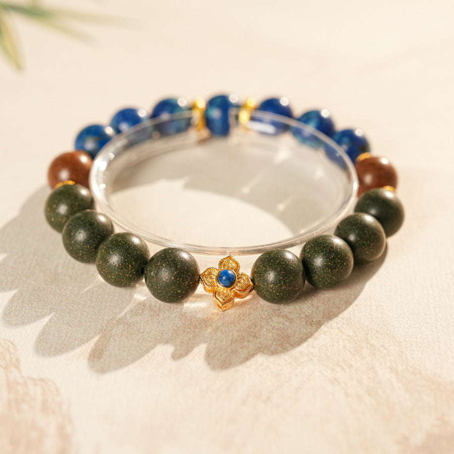 Wood-bead and lapis lazuli bracelet with a gold-tone floral charm set with a lapis cabochon — Woodland Lapis Charm Bracelet by Glazenya.