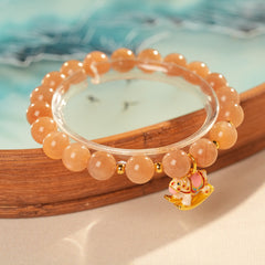 Peach sunstone beaded bracelet with a small gold-tone rocking horse charm — Sunstone Rocking Horse Bracelet by Glazenya.